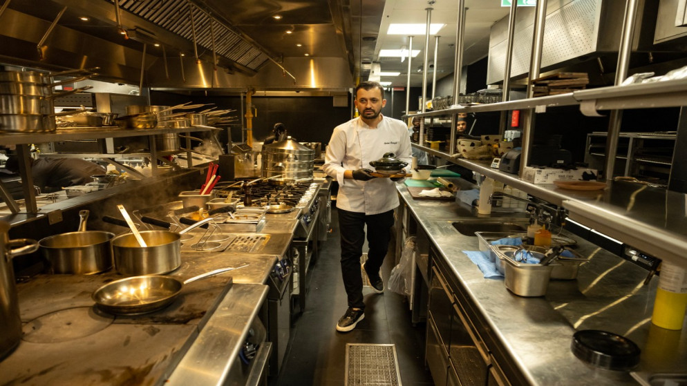الشيف التركي سرهات كارانفيل يعمل في مطبخ مطعم "ووهو"، وهو مطعم يعمل بالذكاء الاصطناعي في دبي. 12 نوفمبر 2025. (أ ف ب)