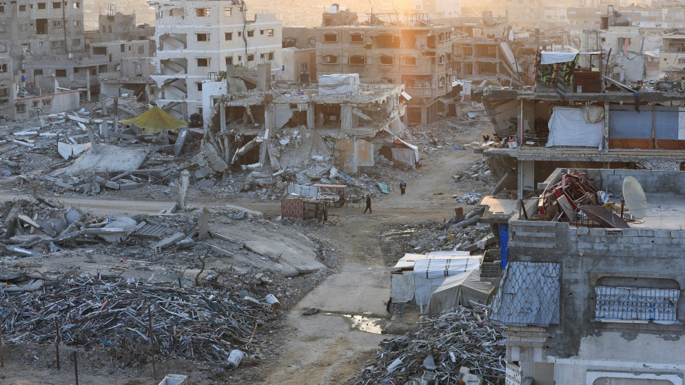 فلسطينيون يسيرون بين أكوام الأنقاض والمباني المتضررة في مدينة غزة، 24 نوفمبر/تشرين الثاني 2025. (رويترز/داود أبو الكاس)