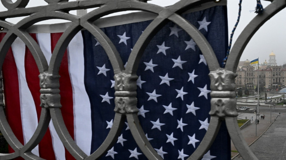 علم أميركي مُعلّق على الجسر بينما يسير المشاة في ساحة الاستقلال في كييف .30 تشرين الثاني 2025.(أ ف ب)