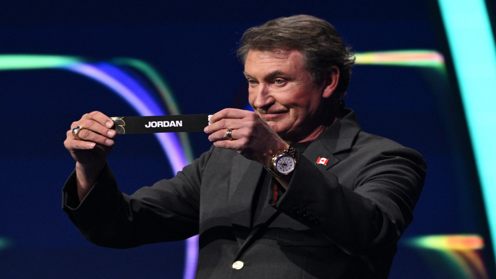 مساعد القرعة واين جريتزكي يسحب أسم الأردن خلال قرعة كأس العالم 2026. واشنطن. 5 كانون الأول 2025. (رويترز)