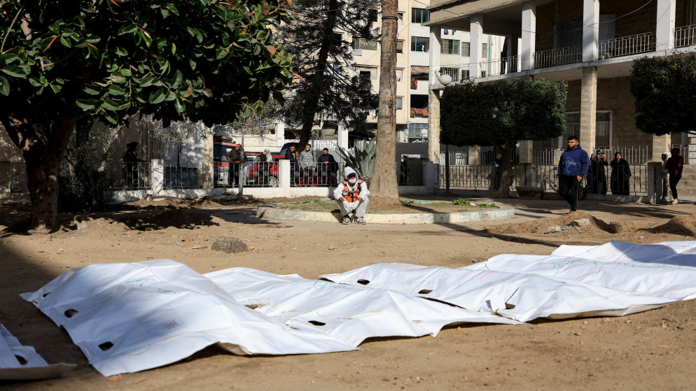 أحد أفراد الدفاع المدني الفلسطيني بجانب جثامين شهداء في مستشفى الأهلي في مدينة غزة، 7 كانون الأول 2025. (رويترز)