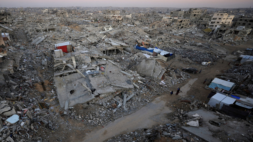 فلسطينيون يقفون بالقرب من أنقاض المباني المدمرة في مدينة غزة، 17 تشرين الثاني 2025. (رويترز)