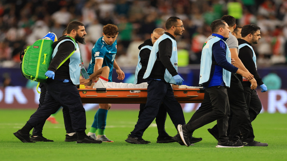 لاعب المنتخب الوطني لكرة القدم يزن النعيمات ينقل على نقالة خارج الملعب في المباراة ضد العراق بعد تعرضه للإصابة. 12 كانون الأول 2025. (رويترز)