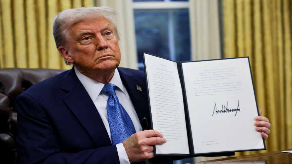 الرئيس الأميركي دونالد ترامب يحمل أمرًا تنفيذيًا موقعًا في المكتب البيضاوي بالبيت الأبيض في واشنطن، 31 كانون الثاني 2025. (رويترز)