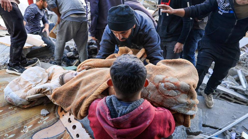 رجل يحمل جثة طفل فلسطيني استشهد بغارة إسرائيلية على مبنى سكني في مدينة غزة، 19 آذار/ مارس 2025. (رويترز)