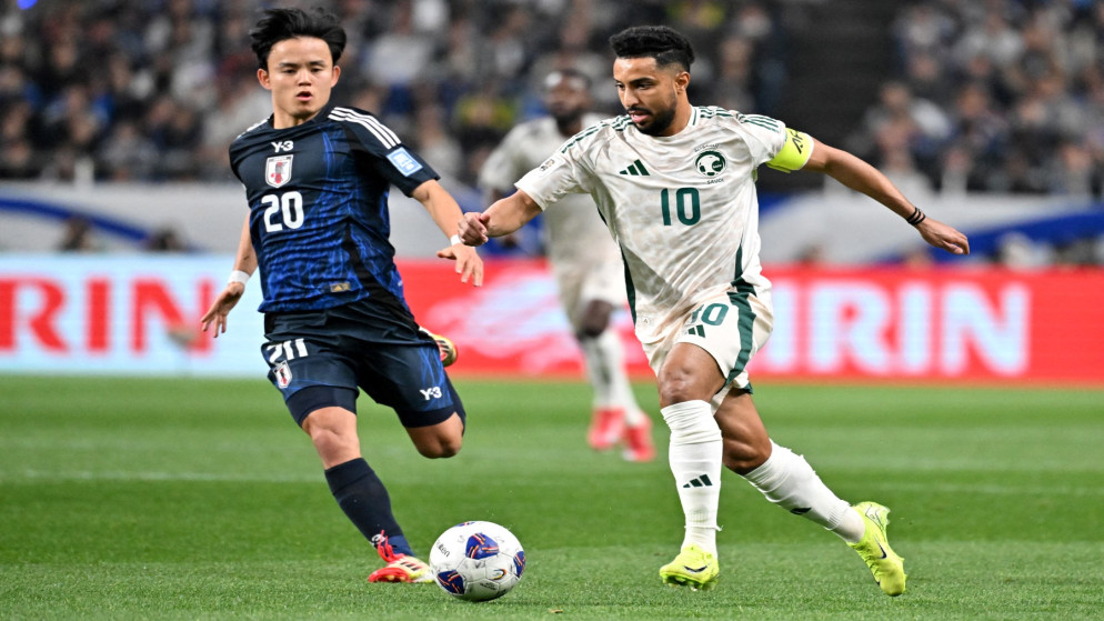 مهاجم المنتخب السعودي سالم الدوسري (يمين) يتنافس على الكرة مع لاعب خط وسط المنتخب الياباني تاكيفوسا كوبو (يسار) خلال مباراة تصفيات كأس العالم 2026 لكرة القدم. سايتاما. 25 مارس 2025. (أ ف ب)