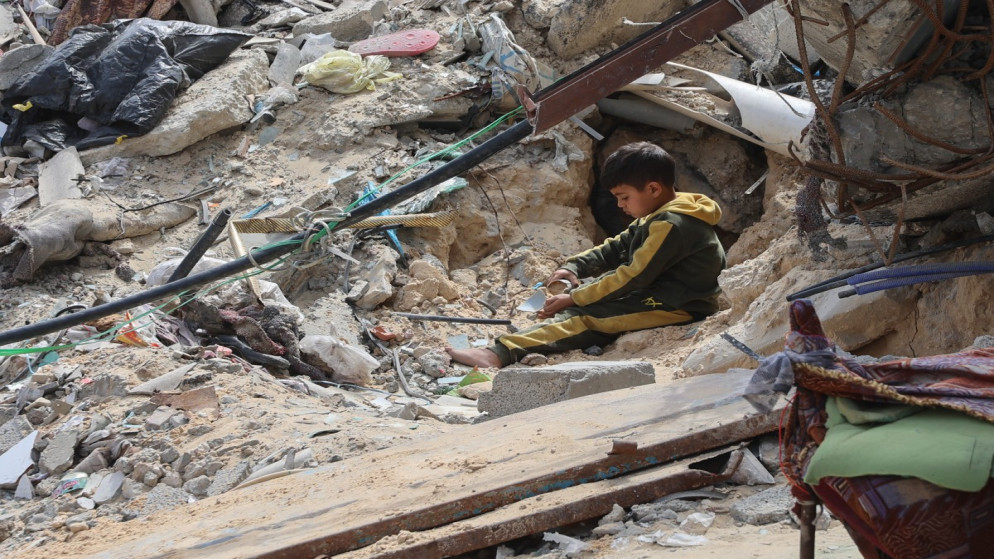 طفل فلسطيني يلعب وسط أنقاض مبنى دُمر خلال الحرب الإسرائيلية على قطاع غزة، 28 آذار 2025. (أ ف ب)