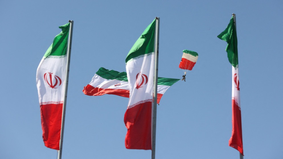 جندي مظلي يحمل العلم الإيراني خلال مراسم عرض يوم الجيش الوطني في طهران، 18 نيسان 2025. (رويترز)