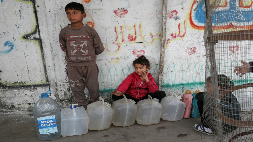 أطفال فلسطينيون يتجمعون بالقرب من خزانات المياه في مدينة غزة، 6 نيسان 2025. (رويترز)