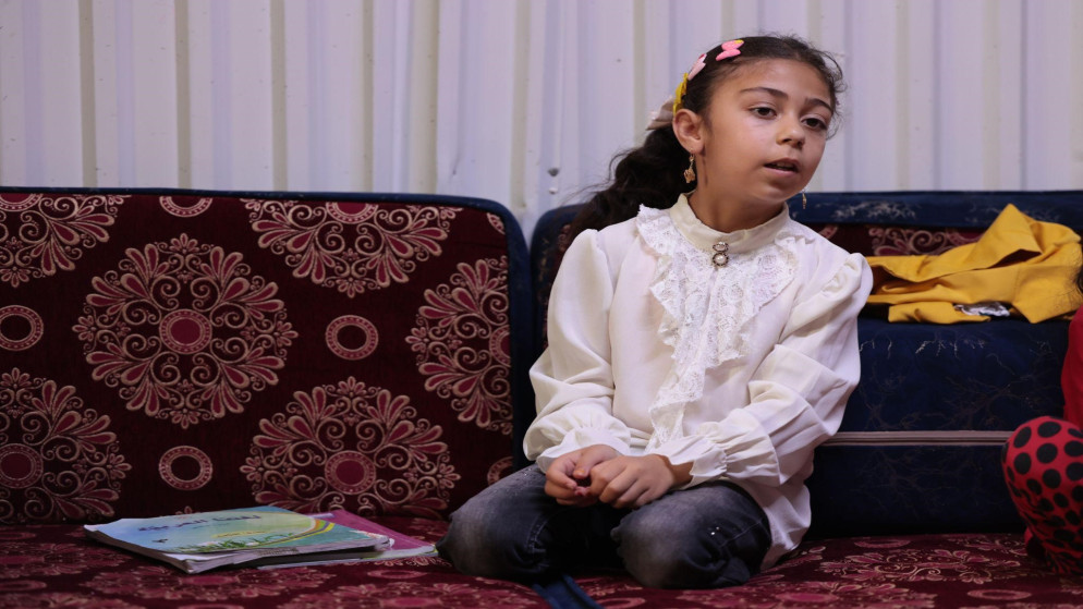 غزل (8 سنوات) من درعا تحضر دروسها وتتخوف من إغلاق المدارس في مخيم الأزرق للاجئين السوريين. (صلاح ملكاوي/ المملكة)