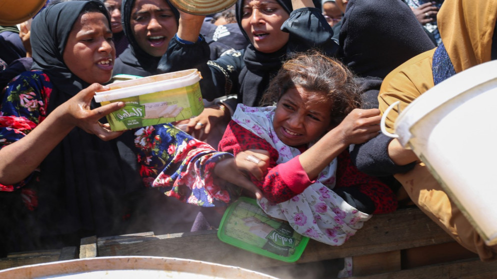 نازحون يتدافعون للحصول على حصة من الطعام من مطبخ خيري بمخيم النصيرات للاجئين وسط قطاع غزة، 5 أيار 2025. (أ ف ب)