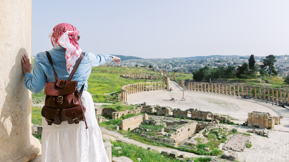 سائحة تنظر إلى ساحة الأعمدة في المدينة الأثرية في جرش. (istockphoto)
