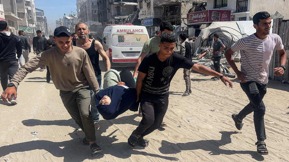 فلسطينيون يحملون شهيدا بعد غارة جوية إسرائيلية في مدينة غزة، 7 أيار 2025. (رويترز)
