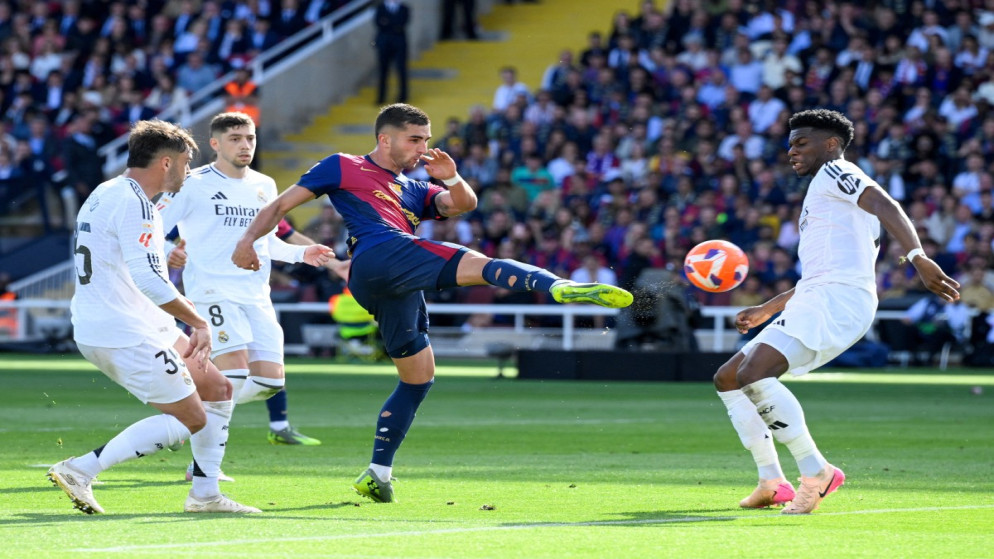 مهاجم برشلونة الإسباني فيران توريس يتنافس على الكرة مع لاعب خط وسط ريال مدريد أوريليان تشواميني خلال مباراة الدوري الإسباني لكرة القدم بين برشلونة وريال مدريد، 11 أيار 2025. (أ ف ب)