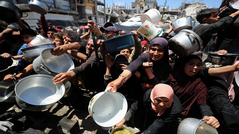 فلسطينيون ينتظرون الحصول على طعام أعدته جمعية خيرية في بيت لاهيا، شمال قطاع غزة، 8 أيار 2025. (رويترز)