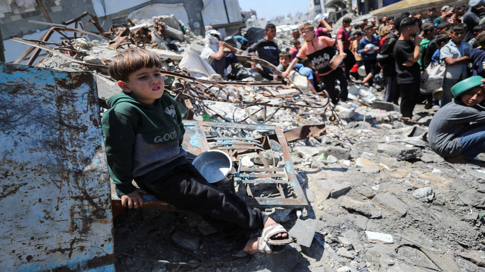 طفل فلسطيني يجلس بينما ينتظر الحصول على الطعام الذي أعدته جمعية خيرية في بيت لاهيا شمالي غزة. 08/05/2025. (رويترز)