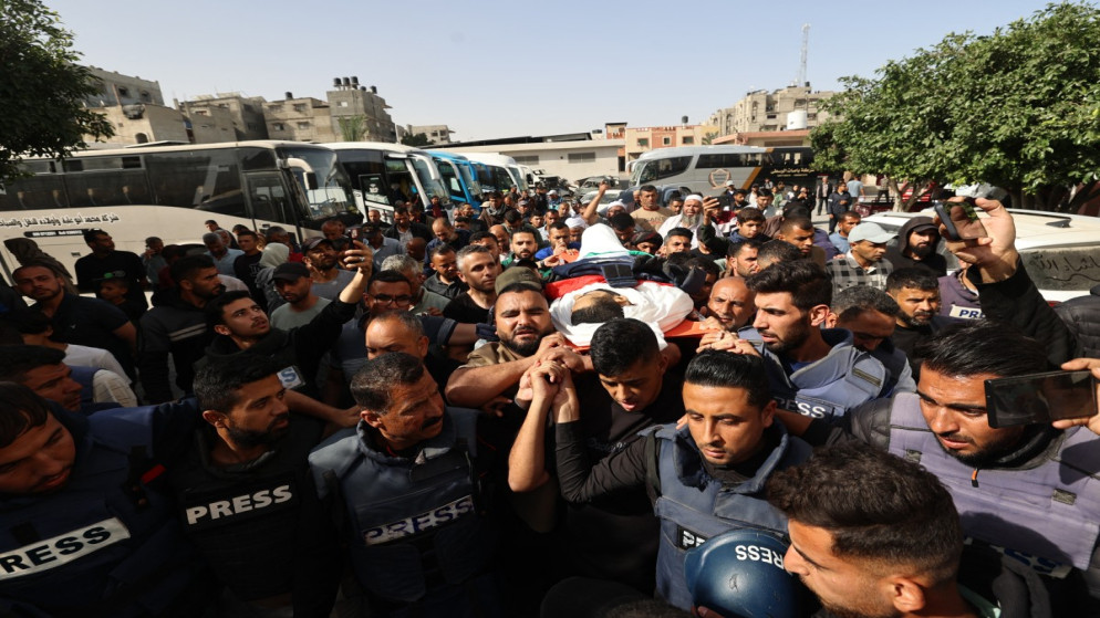 صحفيون فلسطينيون خلال جنازة الصحفي حسن اصليح، الذي استشهد بغارة إسرائيلية أصابت مبنى العمليات الجراحية في مستشفى ناصر في خان يونس . 13 أيار 2025. (أ ف ب)