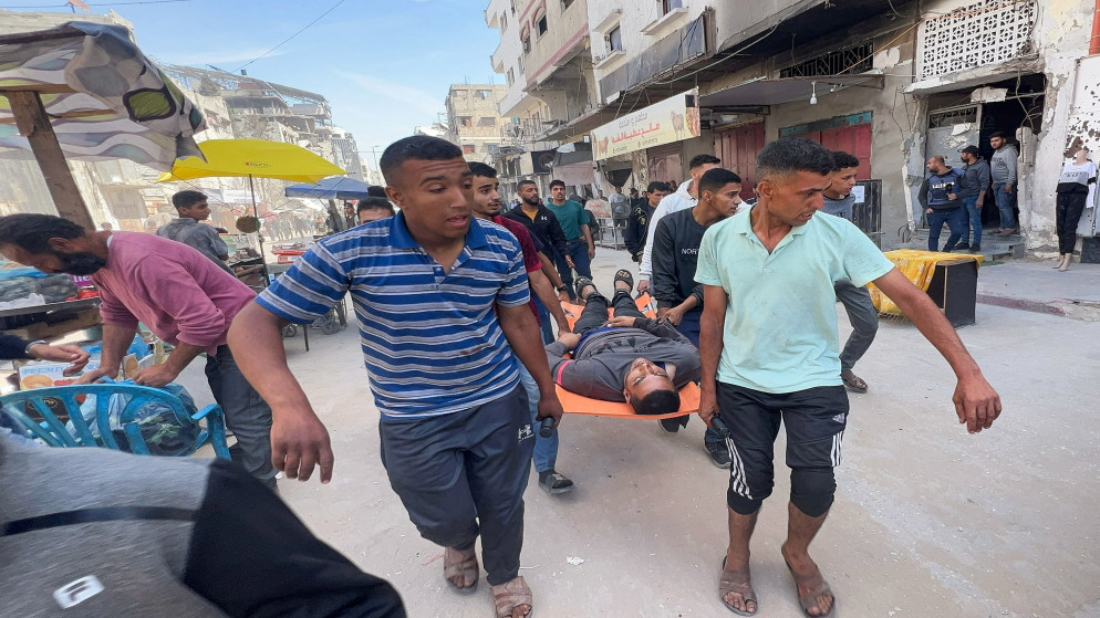 فلسطينيون يحملون شهيدا بعد غارة جوية إسرائيلية في مدينة غزة، 7 أيار 2025.(رويترز)