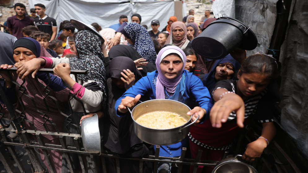 فلسطينيون ينتظرون حصصهم الغذائية خارج مركز توزيع في بيت لاهيا في شمال قطاع غزة في 15 أيار 2025. (أ ف ب)