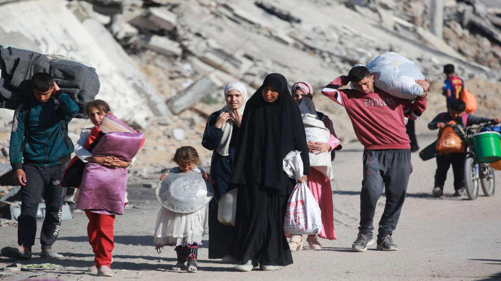فلسطينيون يحملون أمتعتهم أثناء نزوحهم من مدينة غزة في 16 أيار 2025. (أ ف ب)