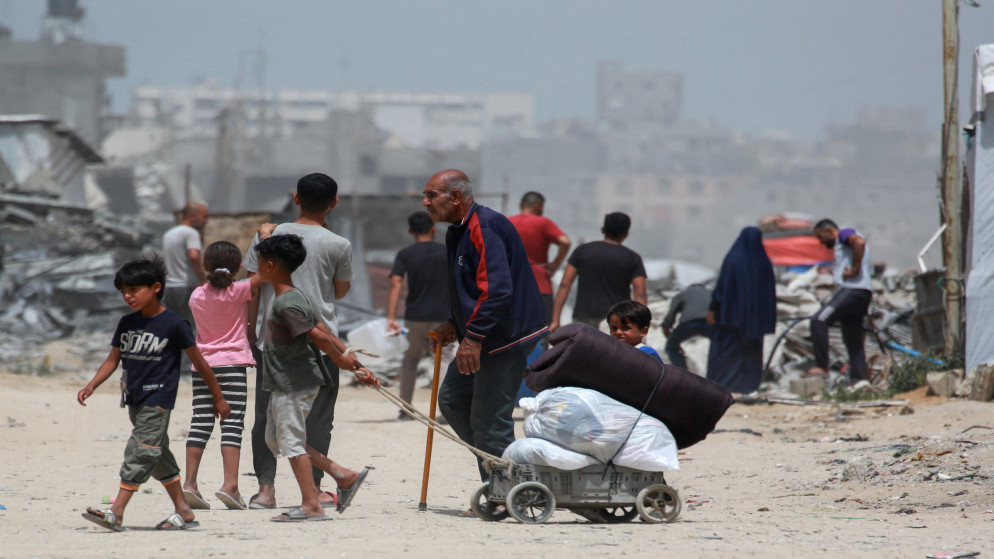 فلسطينيون وسط الدمار الذي خلفه الاحتلال الإسرائيلي، 17 أيار 2025. (أ ف ب)