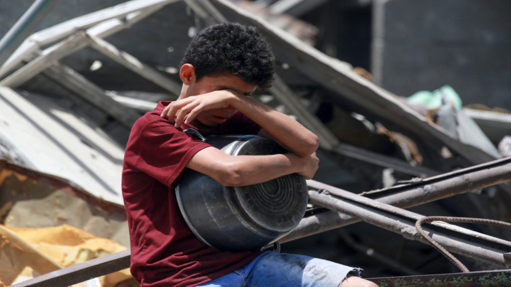 طفل فلسطيني يحمل قدرا في جباليا شمال قطاع غزة، 19 أيار 2025. (أ ف ب)
