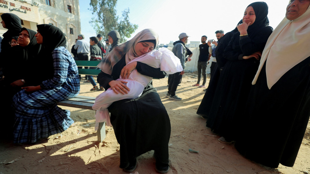 امرأة تحمل جثة طفل فلسطيني استشهد في غارات إسرائيلية، في المستشفى الإندونيسي في بيت لاهيا، شمال قطاع غزة، 28 نيسان 2025. (رويترز)