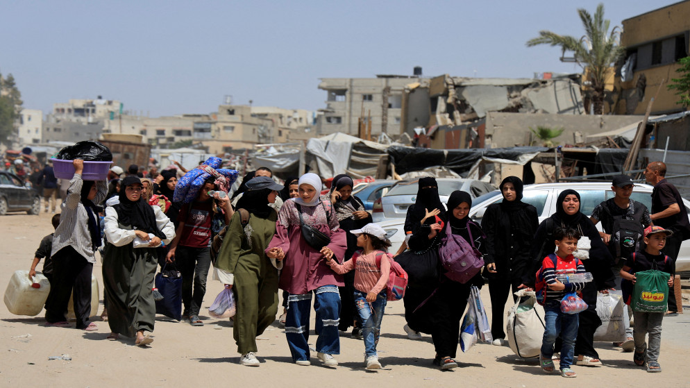 فلسطينيون يحملون أمتعتهم أثناء فرارهم من منازلهم بعد أن أصدر الجيش الإسرائيلي أوامر بالإخلاء من شرق خان يونس، جنوب قطاع غزة، 19 أيار 2025. (رويترز)