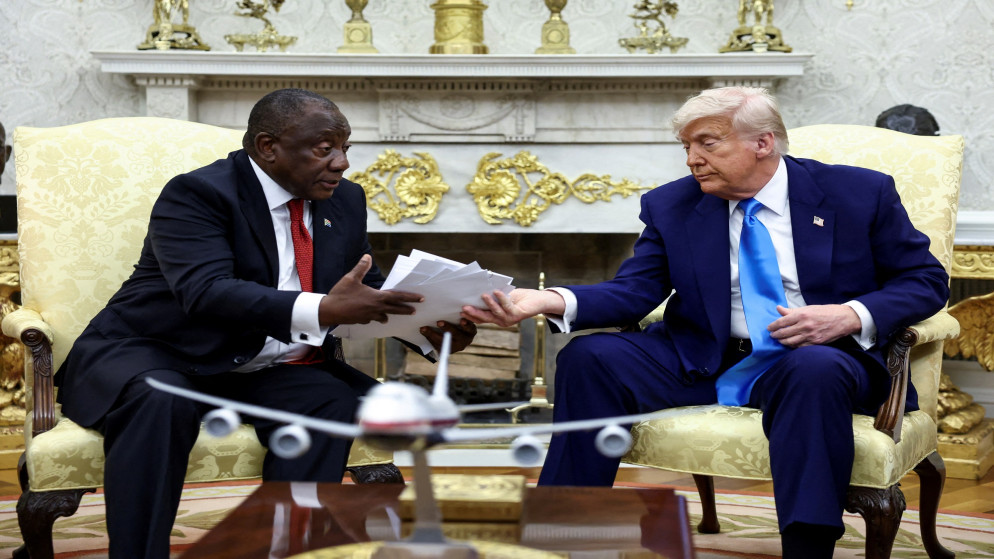 الرئيس الأميركي دونالد ترامب يسلم الرئيس الجنوب إفريقي سيريل رامافوزا نسخًا من مقالات قال إنها تُظهر مواطنين بيضا من جنوب إفريقيا قُتلوا، في المكتب البيضاوي بالبيت الأبيض في واشنطن العاصمة، الولايات المتحدة، 21 أيار/ مايو 2025. (رويترز)