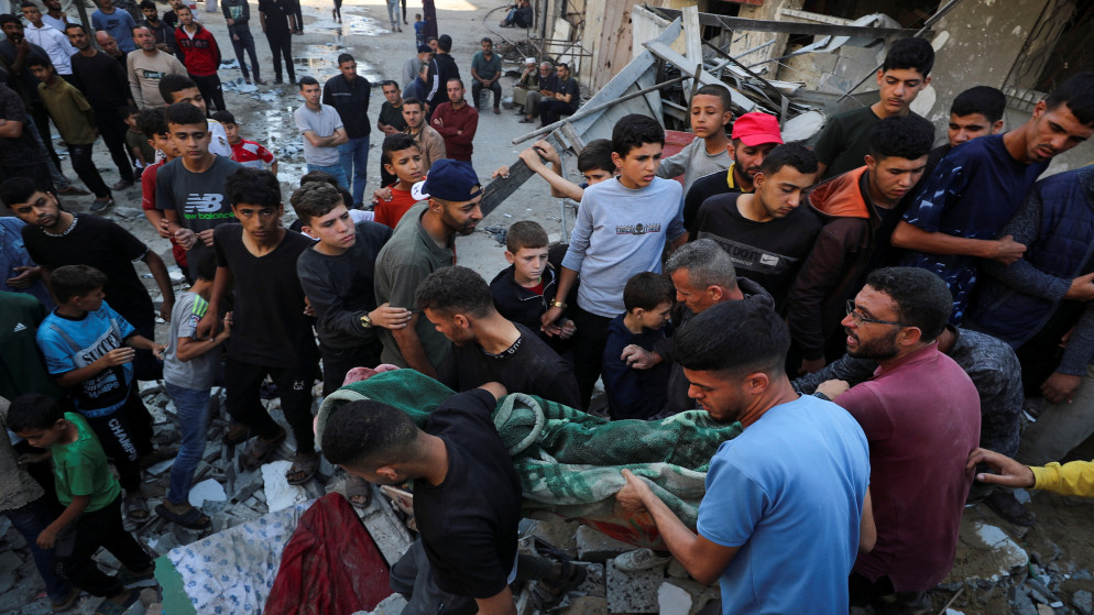 فلسطينيون يحملون جثمان شهيد في موقع غارة إسرائيلية على منزل في جباليا شمال قطاع غزة، 23 أيار 2025. (رويترز)