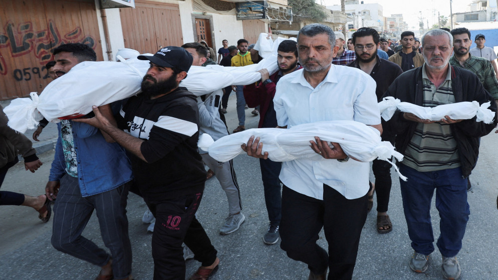فلسطينيون يحملون جثامين شهداء خلال جنازتهم في دير البلح وسط قطاع غزة. 21 مايو/أيار 2025. (رويترز)
