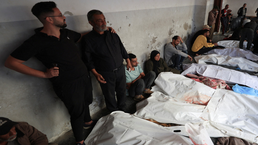 فلسطينيون يتجمعون بالقرب من جثامين شهداء في مستشفى الأهلي العربي المعمداني، في مدينة غزة، 26 أيار 2025. (رويترز)