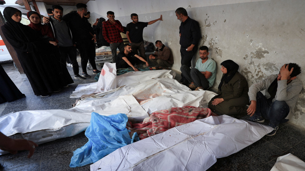 فلسطينيون بجوار جثامين شهداء في مستشفى الأهلي العربي المعمداني، في مدينة غزة، 26 أيار 2025. (رويترز)