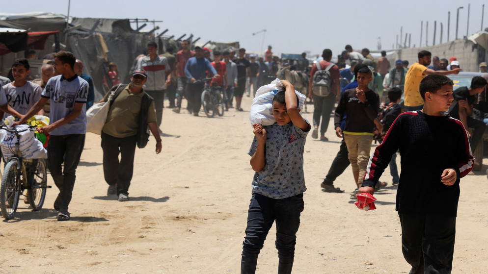فلسطيني يحمل مساعدات تلقاها من مؤسسة غزة الإنسانية المدعومة من الولايات المتحدة، في خان يونس، جنوب قطاع غزة، 28 مايو/أيار 2025. (رويترز)
