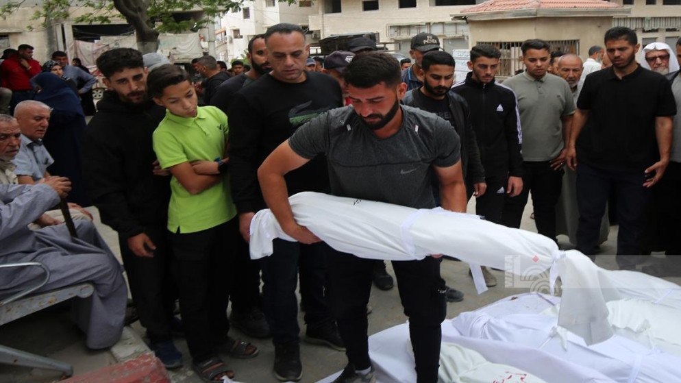 فلسطينيون يتجمعون بالقرب من جثامين شهداء، في مدينة غزة، 26 أيار 2025. (رويترز)