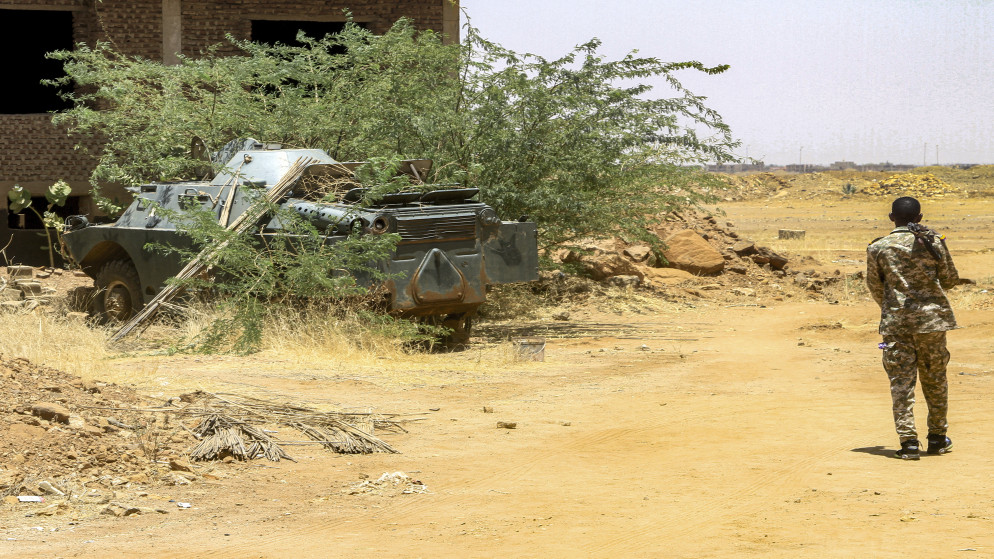 جندي من الجيش السوداني بالقرب من مدرعة تم الاستيلاء عليها بعد سيطرتهم على قاعدة تستخدمها قوات الدعم السريع، في 26 أيار 2025. (أ ف ب)