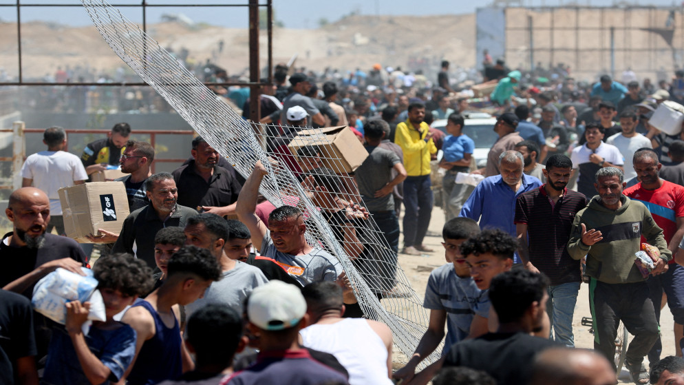 "فلسطينيون يتلقّون مساعدات من مؤسسة غزة الإنسانية، المدعومة من الولايات المتحدة، في وسط قطاع غزة، 29 أيار 2025. (رويترز)"