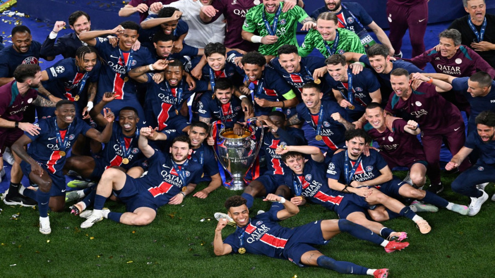 لاعبو باريس سان جيرمان يلتقطون صورة مع الكأس بعد الفوز في مباراة نهائي دوري أبطال أوروبا لكرة القدم بين باريس سان جيرمان وإنتر ميلان في ميونيخ، جنوب ألمانيا. 31 مايو 2025. (أ ف ب)