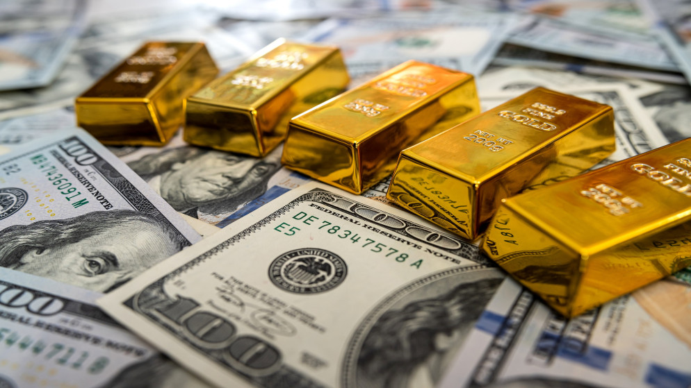 سبائك الذهب على أوراق نقدية من فئة 100 دولار. (istock)