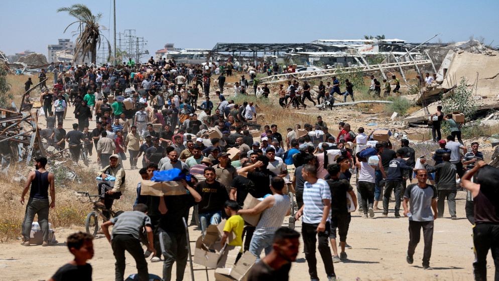 فلسطينيون يتلقون إمدادات الإغاثة من مؤسسة غزة الإنسانية المدعومة من الولايات المتحدة، في وسط قطاع غزة، 29 أيار 2025. (رويترز)