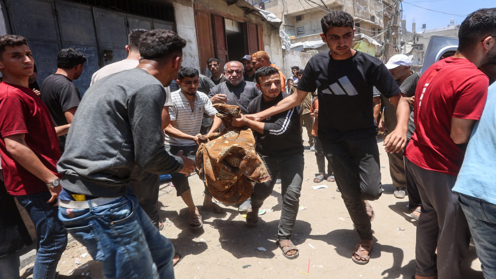 فلسطينيون يحملون جثمان رجل استشهد خلال غارة إسرائيلية على قطاع غزة في 2 حزيران 2025.
