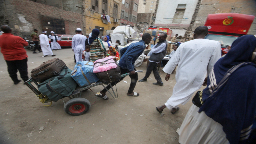 لاجئون سودانيون يحملون أمتعتهم. (رويترز)