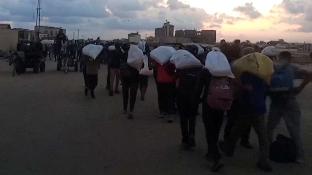 فلسطينيون يحملون مساعدات تلقوها من مؤسسة غزة الإنسانية في رفح جنوبي قطاع غزة. 3 حزيران 2025. (رويترز)