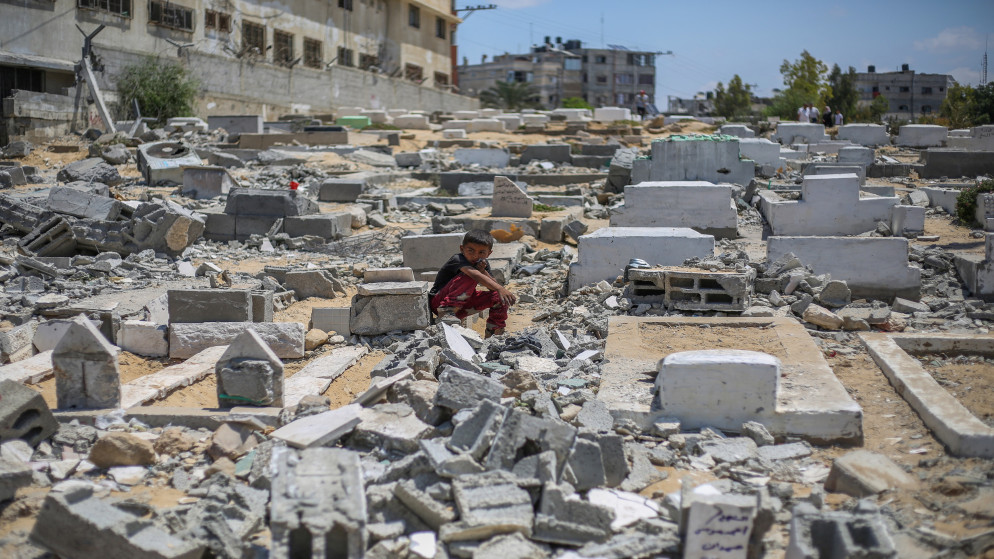 فلسطينيون يزورون القبور المتضررة بعد غارة إسرائيلية استهدفت مسجد أنصار والمقبرة المجاورة في دير البلح في وسط قطاع غزة، 3 حزيران/ يونيو 2025. (أ ف ب)