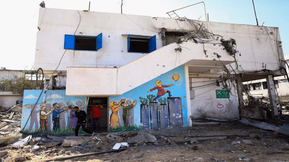 فلسطينيون يتفقدون الأضرار في مبنى يتبع للأونروا في أعقاب غارة إسرائيلية في مدينة غزة، 12 تموز/ يوليو 2024. (رويترز)