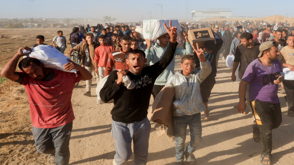 فلسطينيون يحملون إمدادات مساعدات من مؤسسة غزة الإنسانية المدعومة من الولايات المتحدة، جنوبي قطاع غزة، 29 أيار 2025. (رويترز)