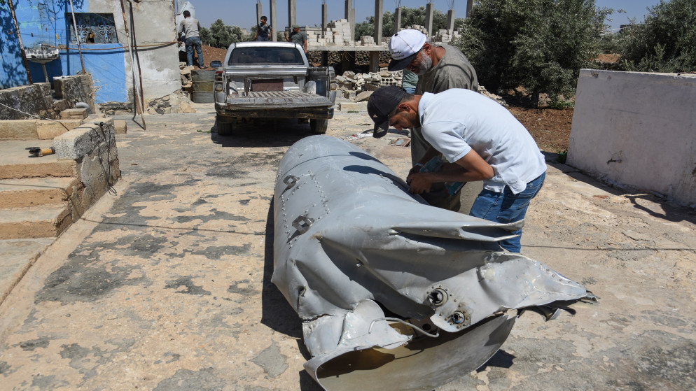 سكان يتفقدون بقايا مقذوف إيراني كان متجهًا إلى إسرائيل، بعد سقوطه في محافظة درعا جنوب غربي سوريا في 13 حزيران/ يونيو/ 2025 (أ ف ب).