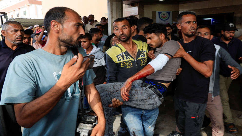 فلسطينيون يحملون رجلا أصيب في غارة إسرائيلية أثناء انتظاره المساعدة في خان يونس جنوبي قطاع غزة، 17 حزيران 2025. (رويترز)