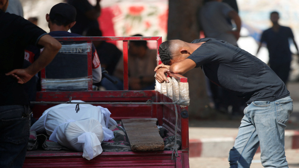 فلسطيني بجانب جثمان شهيد استهدفه الاحتلال الإسرائيلي أثناء سعيه للحصول على المساعدة في شمال غزة. مستشفى الشفاء. 19 حزيران 2025. (رويترز)
