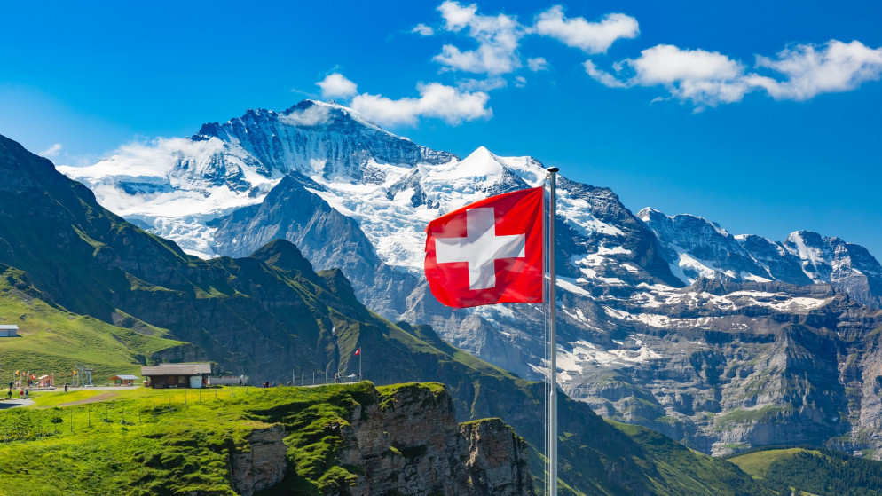 صورة أرشيفية لعلم سويسرا أمام قمم جبال مونش ويونغفراو (shutterstock)